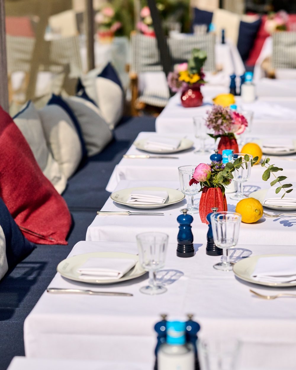 Une longue table dressée sur la terrasse, avec des citrons et des fleurs