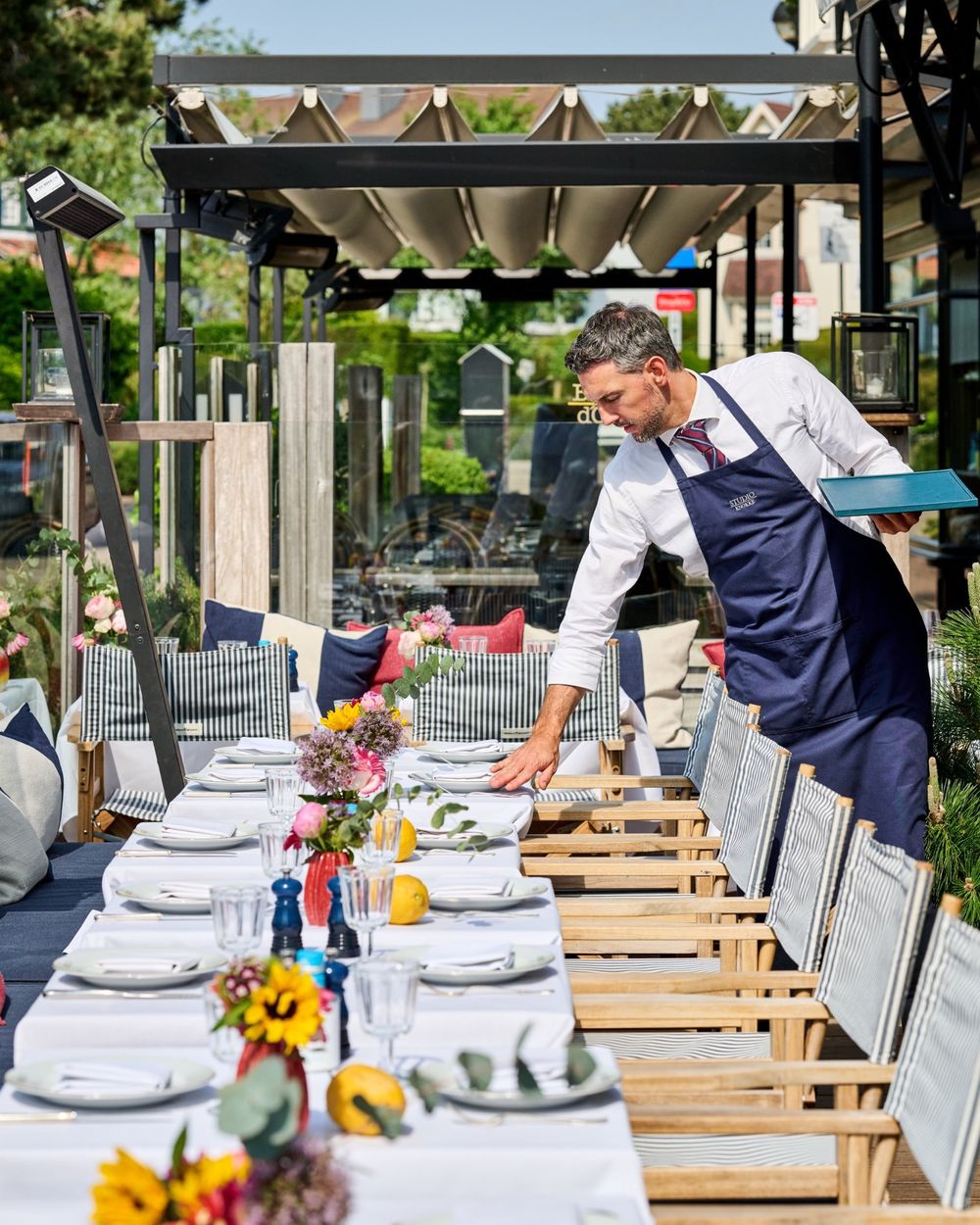 La terrasse dressée de nappes blanches et de fleurs