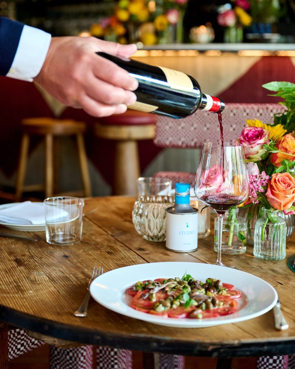 Du vin rouge est servi avec un carpaccio de tomates